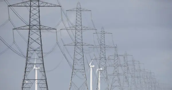 Wind turbines, gas power plant and transmission lines symbolizing UK energy supply