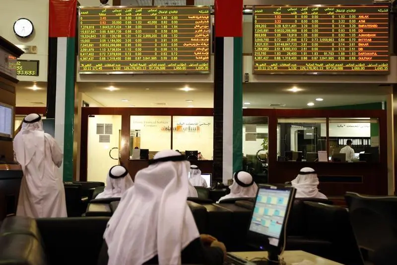 Traders monitor stock prices at a Gulf stock exchange amid global market news